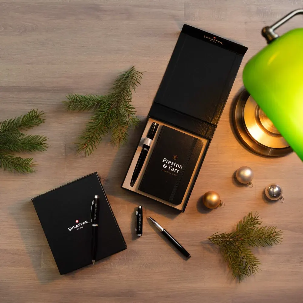 Branded notebooks and pens on a desk